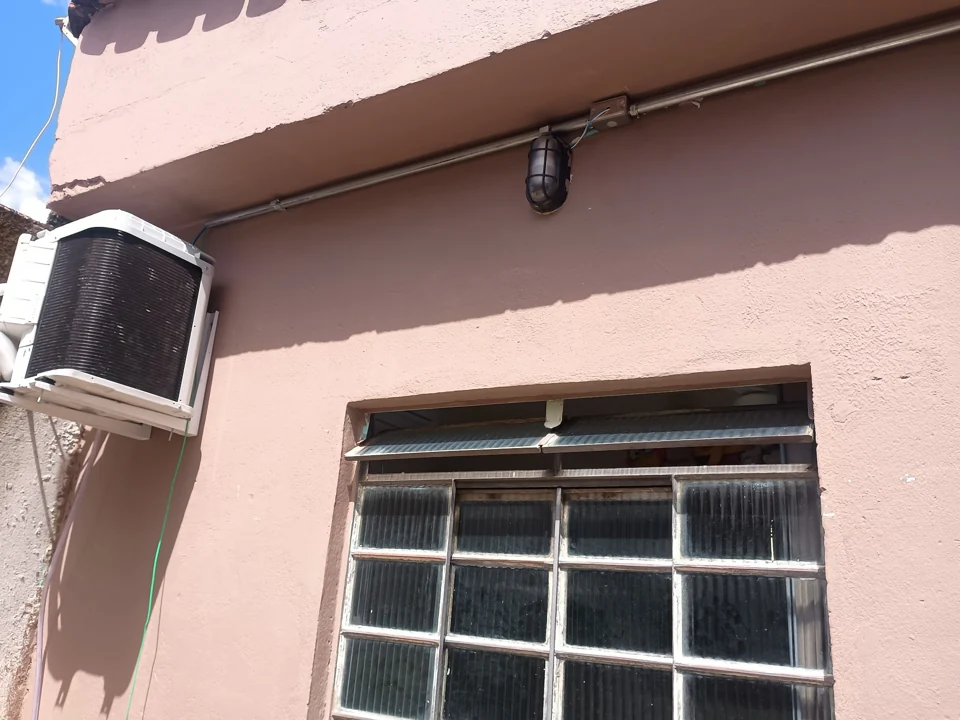 Unidade externa de ar-condicionado instalada em parede de uma casa
