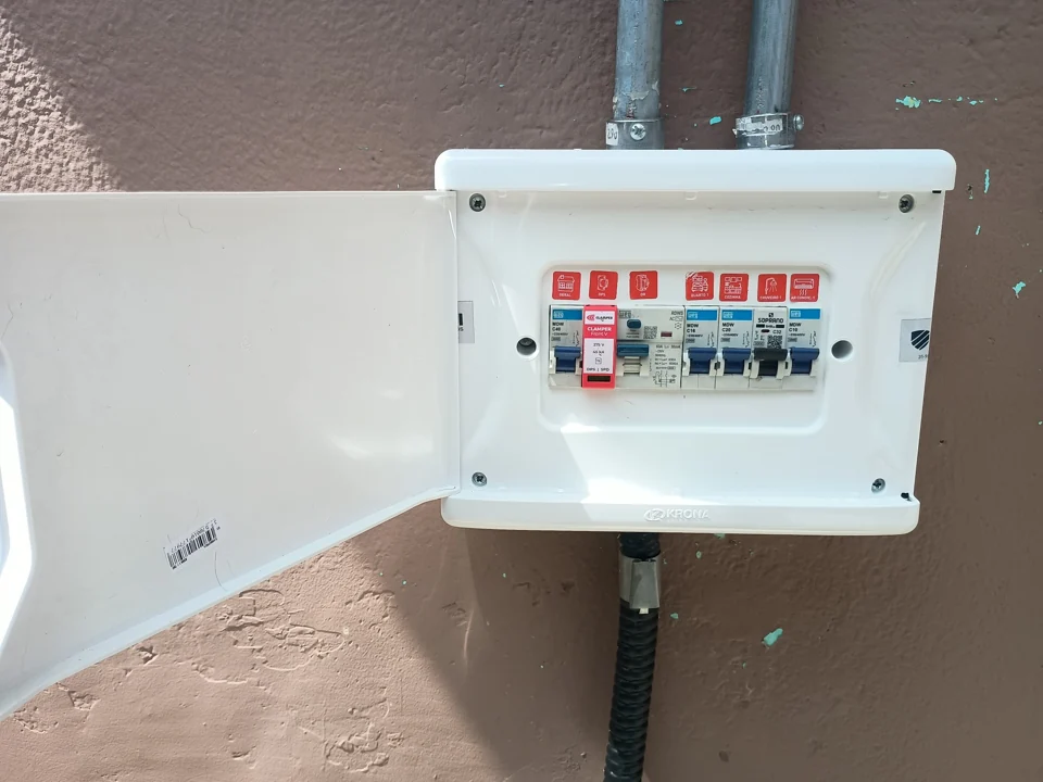 Quadro elétrico branco com disjuntores instalado em parede externa